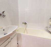 Byt, ktorý dáva zmysel pre rodinu – o 100 000 € lacnejší než dom. - Kúpeľňa s vaňou a regálom v 4-izbovom byte s uloženým prádlom.