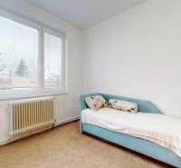 Byt, ktorý dáva zmysel pre rodinu – o 100 000 € lacnejší než dom. - Izba so svetlým gaučom, veľkým oknom a radiátorom v 4-izbovom byte.