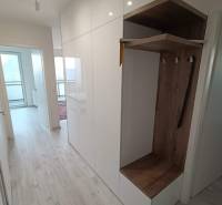 3 izbový byt , Košice - Staré mesto Albelli - Chodba v 3-izbovom byte s bielymi skriňami a vstavaným šatníkom s dreveným dekorom.