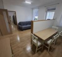 Na prenájom klimatizovaný 2 izbový byt v Moste pri Bratislave - Interiér s pohovkou, jedálenským stolom a podlahou s dreveným dekorom v 2-izbovom byte.