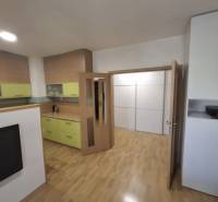 Na prenájom klimatizovaný 2 izbový byt v Moste pri Bratislave - Interiér 2-izbového bytu s podlahou s dreveným dekorom a svetlým nábytkom.