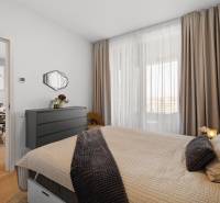 NUERA︱SKY PARK nadštandardný zariadený 2-izbový byt na 15. poschodí - Spálňa s posteľou, závesmi a komodou v 2-izbovom byte s podlahou s dreveným dekorom.