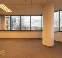 Reprezentatívne administratívne priestory na prenájom  - Interiér kancelárií s veľkými oknami a stĺpom, podlaha s dreveným dekorom.