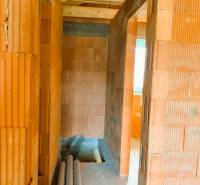 CHATA UZAVRETÁ HRUBÁ STAVBA, KOŠICKÁ NOVÁ VES - GEDER - Interiér s murovanými stenami, dreveným stropom a položenými rúrkami v novej chate.