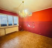 Predaj staršieho RD vo Dvoroch nad Žitavou - Miestnosť v rodinnom dome s lustrom, podlaha s dreveným dekorom a farebnými stenami.