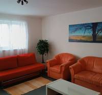 Na Predaj Rodinný dom pozemok 1587 m² v Horných Salibách  - Obývacia izba v rodinnom dome s oranžovou sedačkou, kreslami a obrazom krajiny.