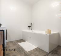 Rezervované 3-izbový byt so záhradou, Šamorín - Kúpeľňa v 3-izbovom byte s bielou vaňou, umývadlom a policami na stene.