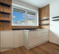 Rezervované 3-izbový byt so záhradou, Šamorín - Kuchyňa v 3-izbovom byte, biele skrinky, podlaha s dreveným dekorom, okno s výhľadom.