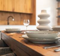 Rezervované 3-izbový byt so záhradou, Šamorín - Jedálenský stôl v 3-izbovom byte s drevenými detailmi a jemným porcelánom.