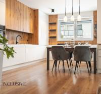 Rezervované 3-izbový byt so záhradou, Šamorín - Kuchyňa v 3-izbovom byte, s podlahou s dreveným dekorom a štýlovým jedálenským stolom.