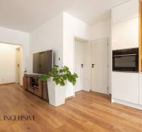 Rezervované 3-izbový byt so záhradou, Šamorín - Obývacia izba v 3-izbovom byte, podlaha s dreveným dekorom, biele steny, televízor.