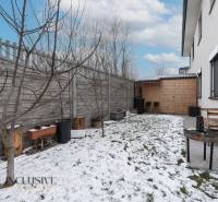 Rezervované 3-izbový byt so záhradou, Šamorín - Záhrada 3-izbového bytu na Kráľoviankach v Šamoríne s drevenou lavičkou a snehovým pokryvím.