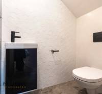 Rezervované 3-izbový byt so záhradou, Šamorín - Kúpeľňa v 3-izbovom byte s bielym obkladom a čiernym umývadlom, šesťhranné dlaždice.