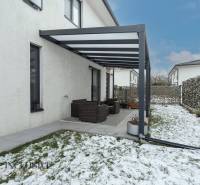 Rezervované 3-izbový byt so záhradou, Šamorín - Terasa s pergolou a snehom na záhrade 3-izbového bytu na ulici Kráľovianky v Šamoríne.
