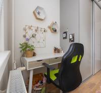 REZERVOVANÝ ZARIADENÝ 4-IZB.  BYT V TOP LOKALITE, DUBNICA NAD VÁHOM - Pracovný kútik s písacím stolom a kreslom v 4-izbovom byte s podlahou s dreveným dekorom.