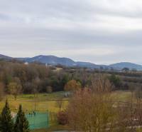 REZERVOVANÝ ZARIADENÝ 4-IZB.  BYT V TOP LOKALITE, DUBNICA NAD VÁHOM - Výhľad z ulice Pod hájom v Dubnici nad Váhom, zahŕňa blízky park a kopce.