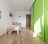 REZERVOVANÝ ZARIADENÝ 4-IZB.  BYT V TOP LOKALITE, DUBNICA NAD VÁHOM - Svetlá spálňa s posteľou a skriňou so zelenými dverami v 4-izbovom byte.