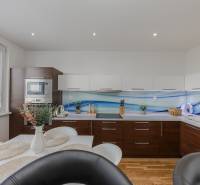 REZERVOVANÝ ZARIADENÝ 4-IZB.  BYT V TOP LOKALITE, DUBNICA NAD VÁHOM - Kuchyňa v 4-izbovom byte s bielymi skrinkami a podlahou s dreveným dekorom.