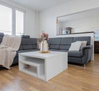 REZERVOVANÝ ZARIADENÝ 4-IZB.  BYT V TOP LOKALITE, DUBNICA NAD VÁHOM - Obývačka v 4-izbovom byte s pohovkou, kvetmi na stolíku a podlahou s dreveným dekorom.