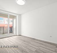 NA PRENÁJOM 3-IZB BYT S BALKÓNOM A ZÁHRADOU,DUN.STREDA - Priestranná miestnosť s podlahou s dreveným dekorom a presklenými dverami v 3-izbovom byte.