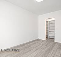 NA PRENÁJOM 3-IZB BYT S BALKÓNOM A ZÁHRADOU,DUN.STREDA - Biela miestnosť s podlahou s dreveným dekorom a otvoreným šatníkom v 3-izbovom byte.