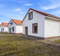 NA PREDAJ 4-IZBOVÉ RD – REZIDENČNÝ PROJEKT, GABČÍKOVO - Rodinný dom v Gabčíkove s bielou fasádou a červenou strechou na trávnatom pozemku.