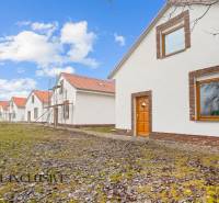 NA PREDAJ 4-IZBOVÉ RD – REZIDENČNÝ PROJEKT, GABČÍKOVO - Rodinné domy v Gabčíkove s bielou fasádou, pred nimi zelený trávnik a modrá obloha.