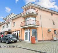 NA PREDAJ NEBYTOVÝ PRIESTOR V DUNAJSKEJ STREDE - Obchodné priestory na Kukučínovej ulici v Dunajskej Strede, s balkónmi a zaparkovaným autom.