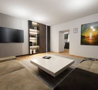 NA PREDAJ 3-IZBOVÝ RD (ČASŤ DVOJDOMU), ZEMIANSKA OLČA - Obývacia izba v rodinnom dome s pohovkou, stolíkom, televízorom a malbou na stene.