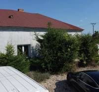 NA PREDAJ 3-IZBOVÝ RD (ČASŤ DVOJDOMU), ZEMIANSKA OLČA - Rodinný dom v Zemianskej Olči s viacerými zaparkovanými autami a zelenými kríkmi pred ním.