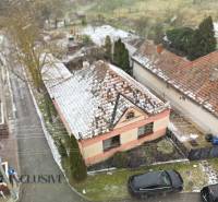 Na predaj 3-izbový rodinný dom, Topoľníky - Rodinný dom v Topoľníkoch pokrytý snehom, so záhradou a zasneženou strechou.