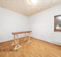 Na predaj 3-izbový rodinný dom, Topoľníky - Priestranná miestnosť v rodinnom dome s podlahou s dreveným dekorom a jednoduchým stolom.