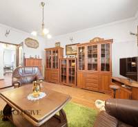 Na predaj 3-izbový rodinný dom, Topoľníky - Obývacia izba v rodinnom dome so skrinkami, kreslami a podlahou s dreveným dekorom.