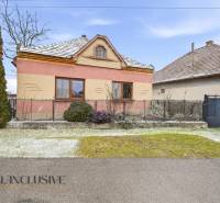 Na predaj 3-izbový rodinný dom, Topoľníky - Rodinný dom v Topoľníkoch s farebnou fasádou, záhradou a zasneženou strechou.