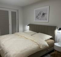 EXKLUZÍVNE-PREDAJ 3-IZBOVÝ BYT POPRAD, širšie centrum 80 m2 s gar.st. - Spálňa v 3-izbovom byte so svetlou posteľou a jemným dekórom na stene.