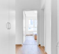 2-izbový byt, NOVÝ, veľkorysý ÚLOŽNÝ PRIESTOR, PARKOVANIE - Interiér 2-izbového bytu s bielymi stenami a podlahou s dreveným dekorom.