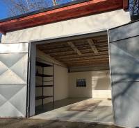 Zrekonštruovaná veľká garáž na ul. Agátova, Dúbravka s pozemkom - Otvretá garáž na Agátovej v Bratislave - Dúbravke s jednoduchým interiérom a regálom.