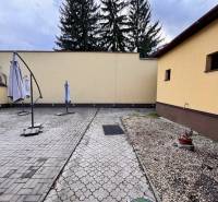 Podnikateľský objekt na prenájom v Lučenci - Plocha gastro priestoru v centre Lučenca so slnečníkmi a dlažbou.