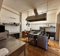 Podnikateľský objekt na prenájom v Lučenci - Kuchyňa v gastro priestoroch so spotrebičmi a nerezovými pracovnými povrchmi, obkladané steny.