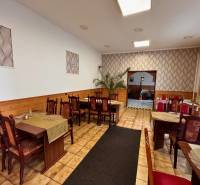 Podnikateľský objekt na prenájom v Lučenci - Gastro priestory s dreveným dekorom, dekoratívnou výzdobou a stolmi pre hostí.