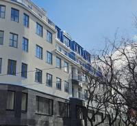 VÝNIMOČNÝ APARTMÁN priamo v centra mesta - projekt UNO Poštová - Budova v Bratislave - Starom Meste na Poštovej ulici so stromami v popredí.