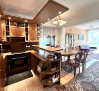 RD 4 izbový na veľkorysom pozemku, Ivanka pri Dunaji - Interiér rodinného domu s kuchynskou linkou, jedálenským stolom a podlahou s dreveným dekorom.