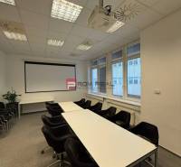 Skvelá ponuka kancelária 60 m2 v centre Bratislavy - Konferenčná miestnosť v kanceláriách s projektorom, stolmi a stoličkami, pripravená na stretnutia.