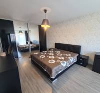 Reprezentatívny 2 izb.byt na prenájom SOHO TOWER Komárno ! - Spálňa v 2-izbovom byte s veľkou posteľou a podlahou s dreveným dekorom.