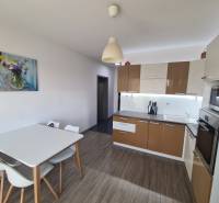 Reprezentatívny 2 izb.byt na prenájom SOHO TOWER Komárno ! - Kuchyňa v 2-izbovom byte s podlahou s dreveným dekorom a jedálenským stolom.