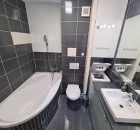 Reprezentatívny 2 izb.byt na prenájom SOHO TOWER Komárno ! - Kúpeľňa v 2-izbovom byte s vaňou, práčkou, umývadlom a tmavými obkladačkami.