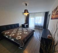 Reprezentatívny 2 izb.byt na prenájom SOHO TOWER Komárno ! - Spálňa v 2-izbovom byte s posteľou, skrinkou a podlahou s dreveným dekorom.