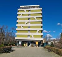 Reprezentatívny 2 izb.byt na prenájom SOHO TOWER Komárno ! - Viacposchodový bytový dom v Komárne s moderným dizajnom, obklopený zeleňou a lavičkami.