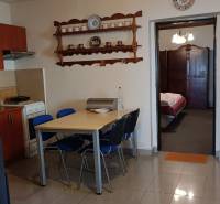 Na predaj RD na bývanie alebo investičná príležitosť Horné Saliby - Jedálenský kút a kuchyňa v rodinnom dome s poličkou a stropným ventilátorom.