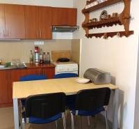 Na predaj RD na bývanie alebo investičná príležitosť Horné Saliby - Jedáleň v rodinnom dome s kuchynskou linkou, stolom a policou na stene.